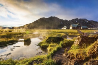 Sunrise Park Landmannalaugar. Above the source of thermal water steam rises. White nights in