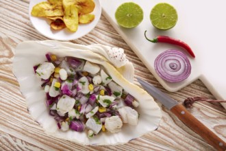 Ceviche peruvian recipe with fried banana and ingredients on wooden table