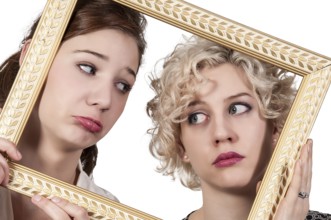 Beautiful women looking through an ornate picture frame