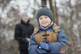 Six year old boy smiling during makeing snowball