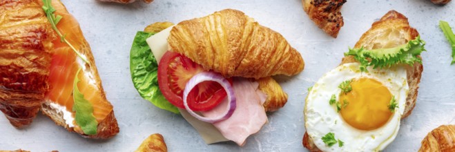 Croissant sandwich variety panorama. Different stuffed croissants, overhead flat lay shot. Rolls