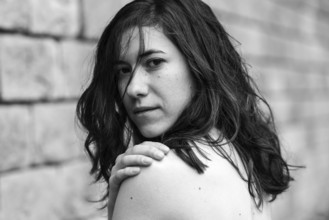 Portrait of a 27 year old white woman showing her naked schoulde, Brussels, Belgium, Europe