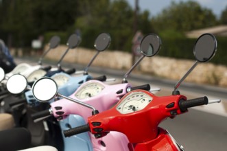 A line of mopeds/scooters on the city street