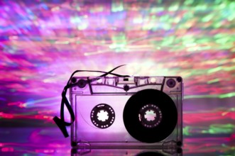 Cassette tape and multicolored pink blue lights on background