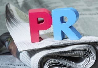 Word PR on newspaper. Wooden letters