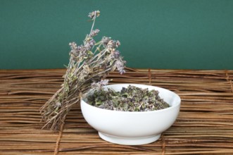 Dried thyme in a bowl on a wooden base