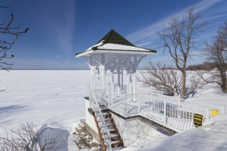 Winter, small private pavilion next to the snow and ice covered Saint Lawrence River, Lery,