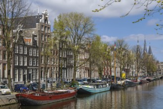 View of Amsterdam canal with historic houses and boat, Netherlands