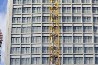 Construction crane in front of the window front of a high-rise building, Bremen, Germany, Europe
