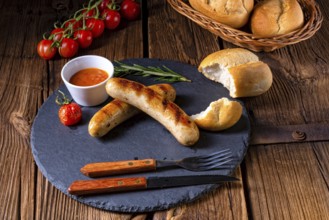 Rustic bratwurst with ketchup and fresh rolls