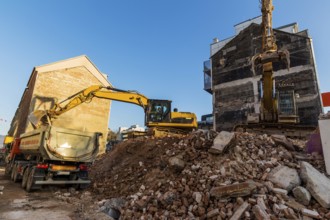 Excavators on a building site demolishing a house, creating space for new flats and living space