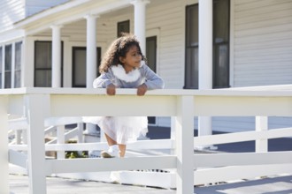 Kid toddler girl playing climbing a fence outdoor latin ethnicity