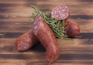 Image shows smoked sausages on a vintage wooden plate
