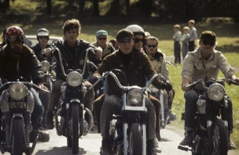 In the 1960s. Motorcyclists on the road together. Cool and trendy looking riding thir bikes. The