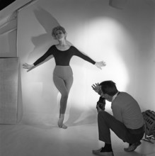 1950s photographer. A woman is posing for a photographer wearing a typical 1950s black jumper and
