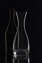 Empty glass and bottles on the black background