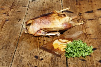 Roasted goose on wooden table