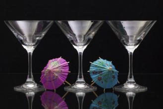 Three empty glasses of champagne with decoration (paper umbrellas)