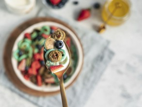 Trendy food - pancake cereal. Bowl of colorful mini cereal pancakes in spoon with milk. Tiny