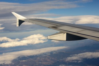 Airplane during flight with the sky and clouds on the background