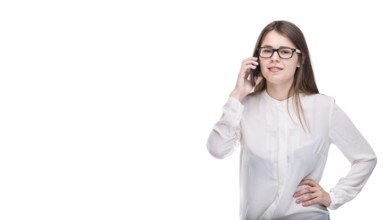 Smiling businesswoman in glasses talking on mobile phone. Beautiful young girl in white shirt on
