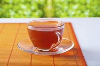 Transparent cup with tea on table