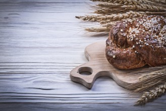 Chopping board wheat rye ears bread stick on wooden background