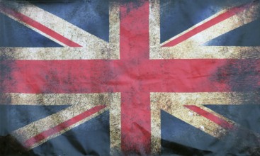 A full frame image of an old stained dirty union jack british flag with dark crumpled edges