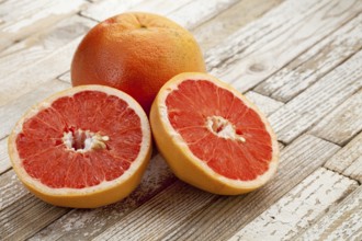 Red cut grapefruit on white grunge wood table with paint peeling off