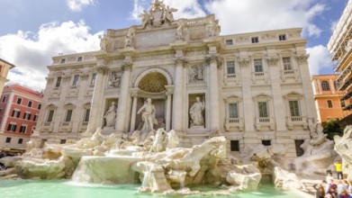 Tourists and people walking next to the Trevi Fountain in a sunny day with clouds, one of the most