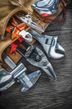 Leather building belt with construction tooling on wooden board