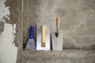 Construction stainless steel trowel tools and spatula on cement mortar wall