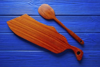 Chef tool spatula and table board on a blue wooden background