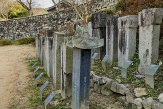 Gochang, South Korea, December 4, 2020: Stone stelae honoring Korean monks with fortress wall in