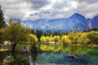 The Dolomites are covered with clouds. Lake Fuzine in Northern Italy. Magnificent colors of autumn.