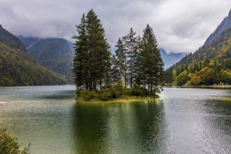The surface of the lake Di Predil is covered with light ripples. Cold autumn in the Alps. Small