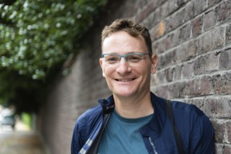 Portrait of an attractive forty year old man standing against a wall, Kortrijk