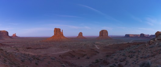 A panorama picture of the Monument Valley landscape in the early evening or night, with the West