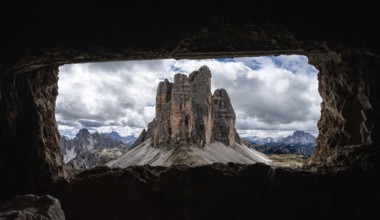 View out of an old military tunnel window towards the iconic Three Peaks mountain in the Dolomite