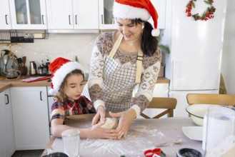 Mom and daughter in the white kitchen are preparing cookies for Christmas and new year. Family day,