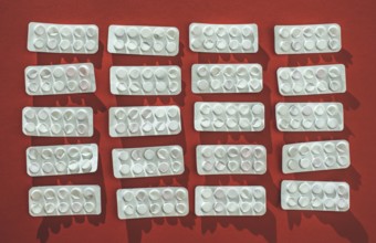 Packs of pills on red background