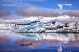 The concept of extreme northern tourism. Ice floes are reflected in the smooth water surface of Ice