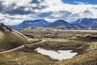 Summer trip to Iceland. The dirt road in a valley surrounded by mountains