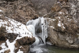 The waterfalls, which are not completely frozen in winter, flow down from the porous rocks