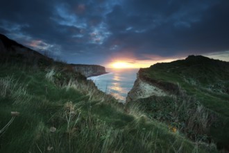 Sunset over cliffs in ocean, Etretat, France, Europe