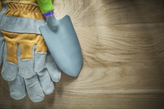 Gardening shovel safety gloves on wooden board