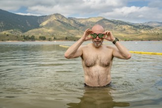 Active senior man finishing swimming workout in a mountain lake - Horsetooth Reservoir in northern