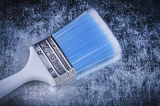 Paint brush on scratched metallic background construction concept