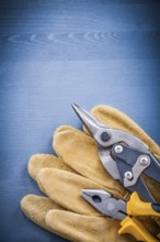 Pliers steel cutter pair of safety gloves on wooden board