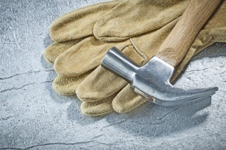 Leather safety gloves claw hammer on metallic background construction concept